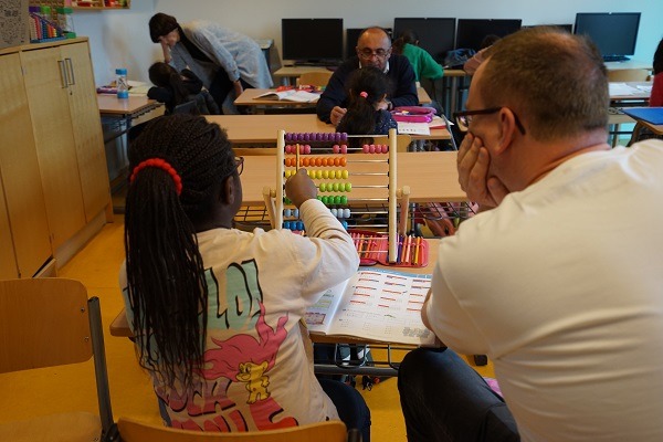 Ein Teilnehmer von TD Synnex hilft einem Kind bei den Mathehausaufgaben.