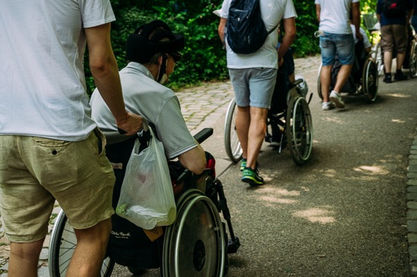 Die Teilnehmer von Cyoss unterstützen beim Ausflug in den Tierpark Hellabrunn mit Rollstuhlfahrern im Rahmen des Corporate Volunteering.
