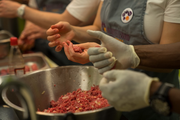 Ehrenamtliche Mitarbeiter von AmRest kochen beim Social Day Des mach ma.